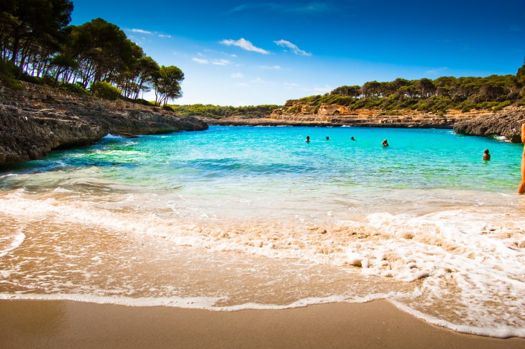 Mediterraner Strand umgeben von Palmen