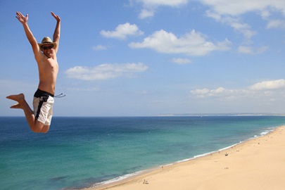 springender Urlauber am Strand